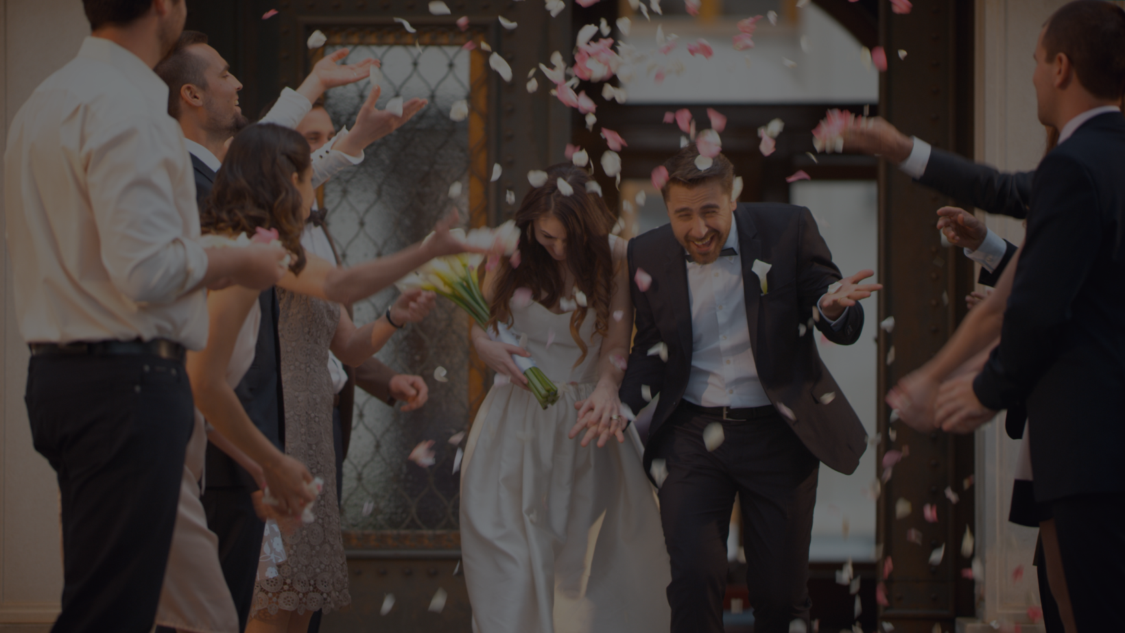 A bride and groom being showered in confetti as they exit their wedding ceremony. Wedding song checklist.